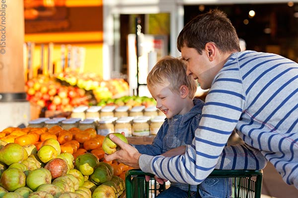 Father and son picking out fruit