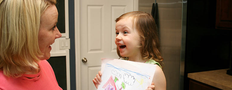 child showing parent her artwork