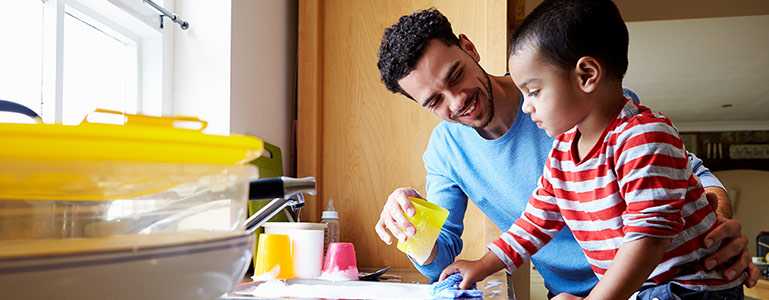 father and son washes dishes