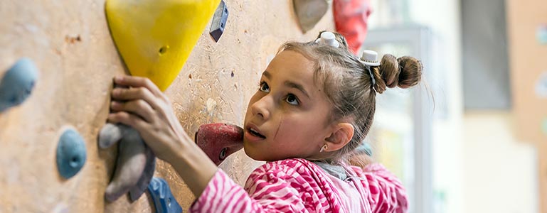 young girl climbing wall