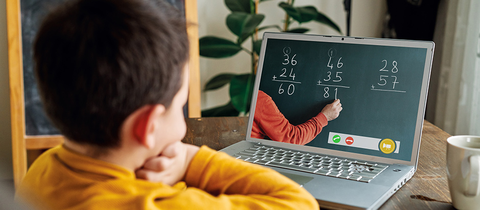 child looking at lesson on laptop