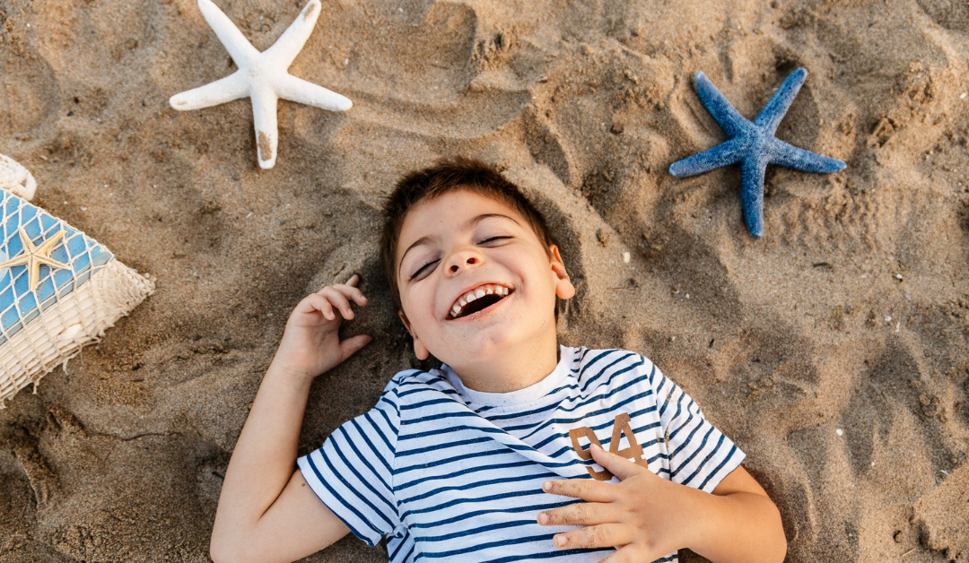 Boy with special needs relaxing on the beach with starfish nearby on the sand